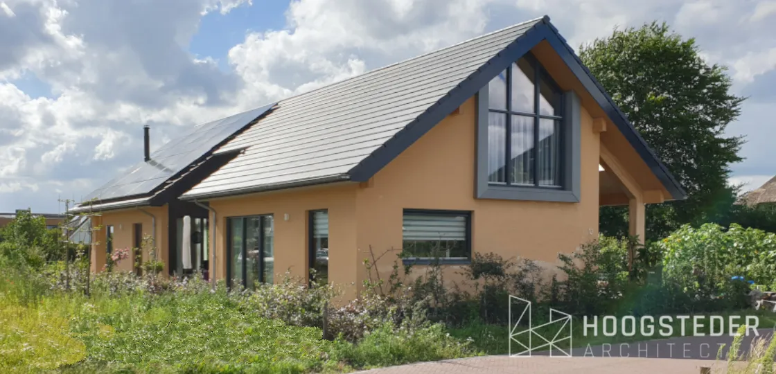 Woning met okerkleurige kalkhennep gevel, zonnepanelen op het dak en een wilde tuin