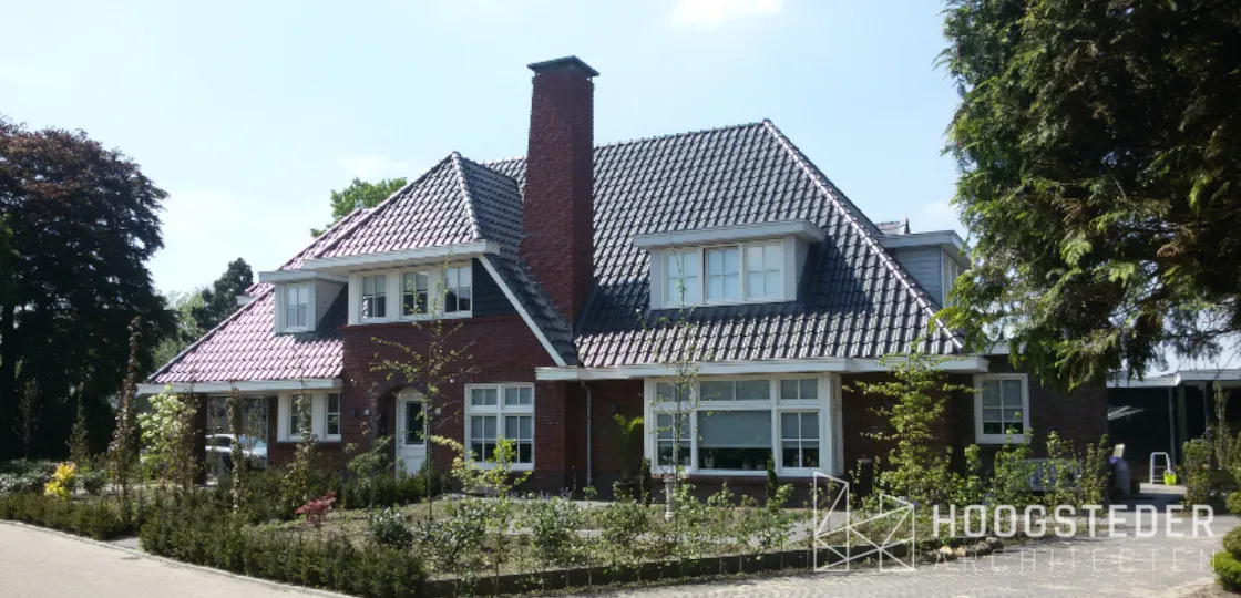 Villa in jaren 30 stijl met rode baksteen, brede schilddaken en een gemetselde schoorsteen
