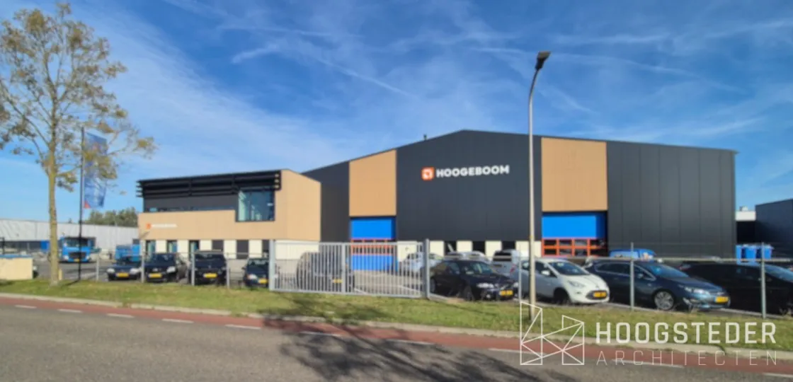 Het terrein van Hoogeboom vanaf de weg, met links het kantoor en rechts de hal met houtkleurige vlakken en blauwe deuren