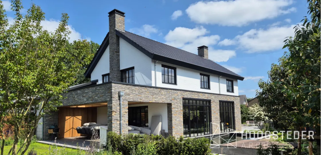Villa met natuurstenen plint, wit stucwerk erboven en een overdekte veranda met stalen puien