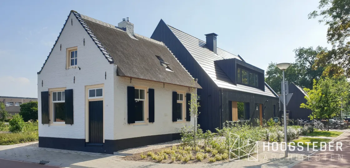 Wit gepleisterd tolhuisje met daarachter een zwarte nieuwbouwwoning met houten gevel