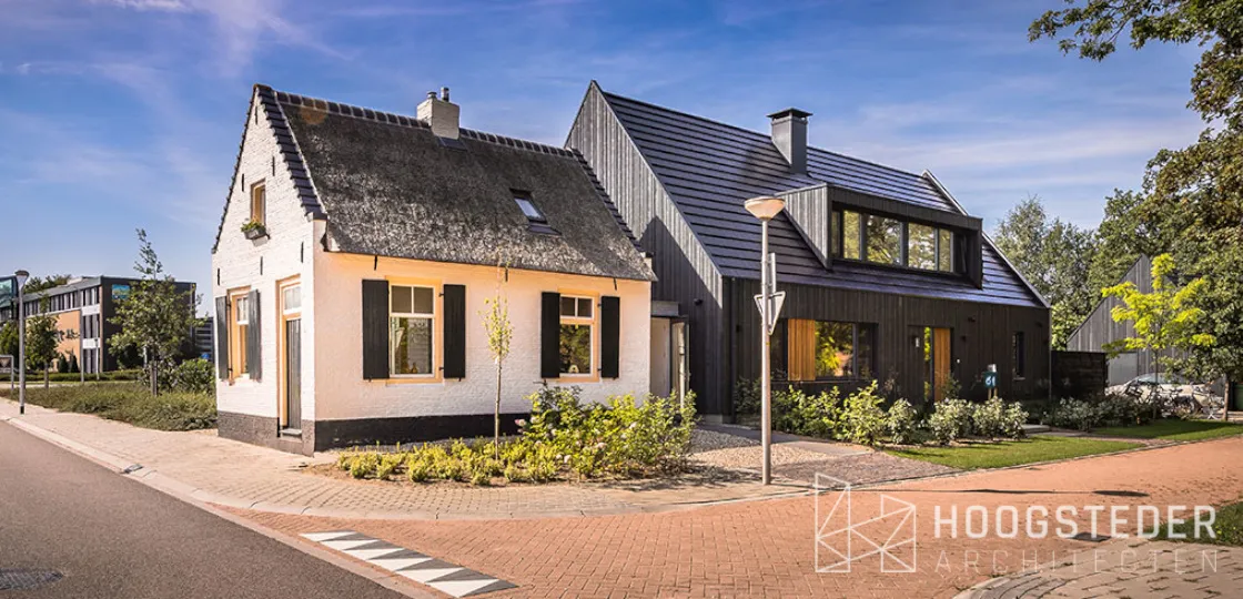 Wit gepleisterd tolhuisje met daarachter een zwarte nieuwbouwwoning met houten gevel