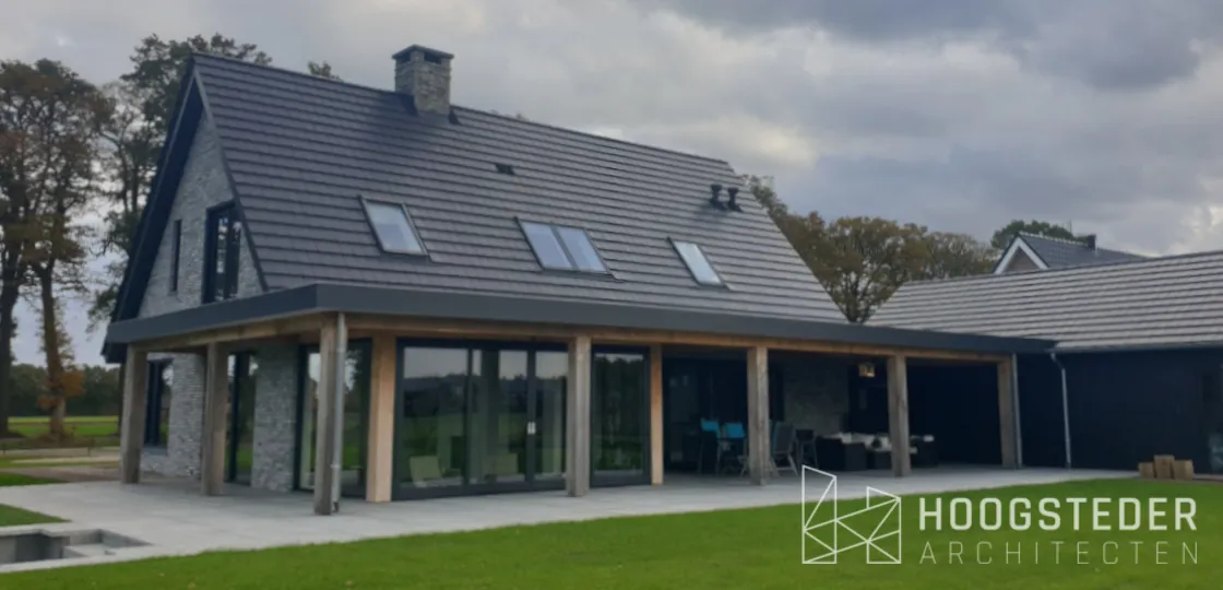 Woning met natuurstenen gevel, houten kolommen en een diepe overdekte tuinkamer